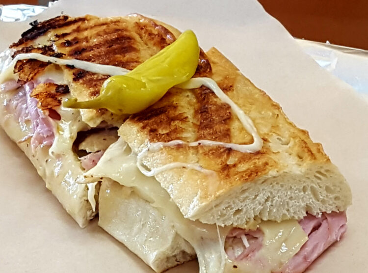 Cuban panini sandwich with roasted pork, ham, Swiss cheese, pickles and mustard