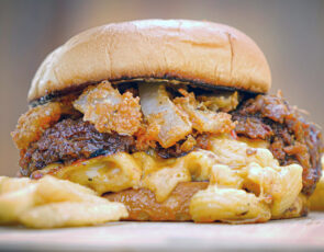 The Fat Guys Pork and Mac Stack combines all your favorites into one OMG burger: BBQ pulled pork and a Mac & Cheese patty, on toasted bun, topped with the Fat Guys Grill’s signature onion fries. Photo: Jesse Harding.